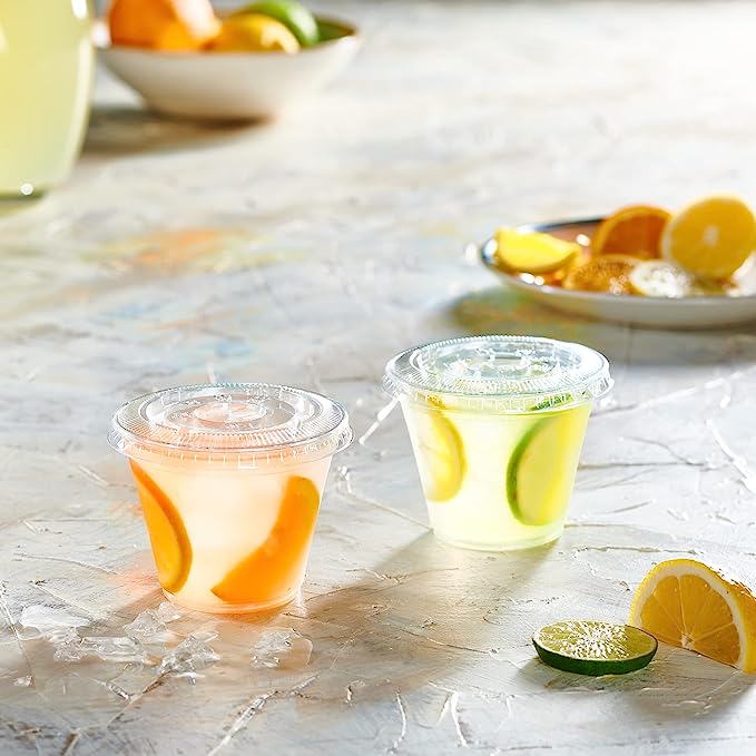 clear plastic disposable cups with lids filled with fruit-infused drinks and citrus slices